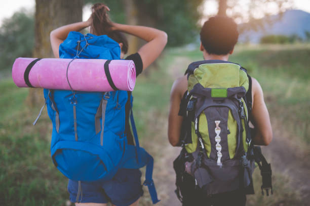 istock Close rear view of young couple with backpack through forest 853418322