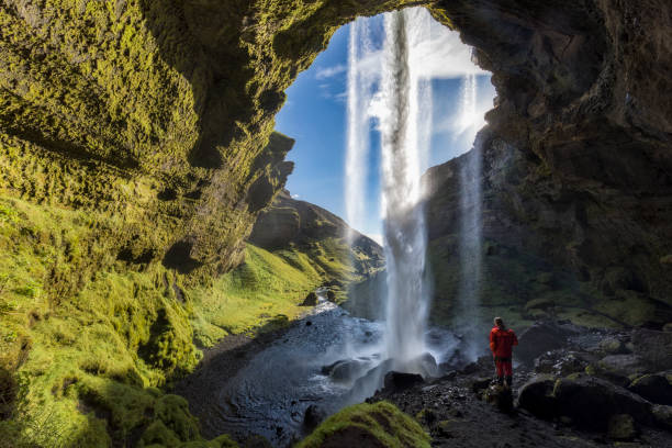Hiker at Majestic Kvernufoss Waterfall in Iceland Blue Sky, Famous Place, Waterfall, Iceland golden circle route photos stock pictures, royalty-free photos & images