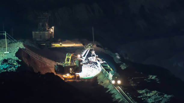 istock Heavy industry machines at dusk working in open pit mine 853441856