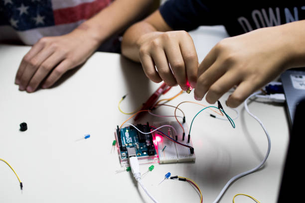 two children build a prototype circuit with a red laser stock photo