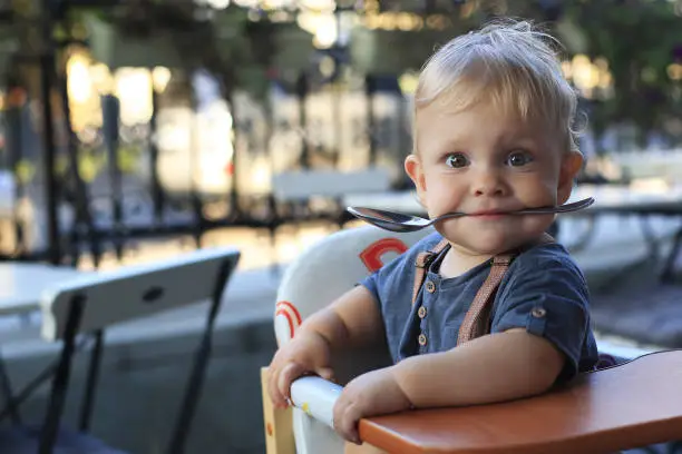 Photo of Little boy is sitting in a cafe