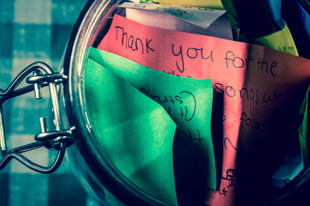 Thank you jar with messages written on coloured paper stock photo