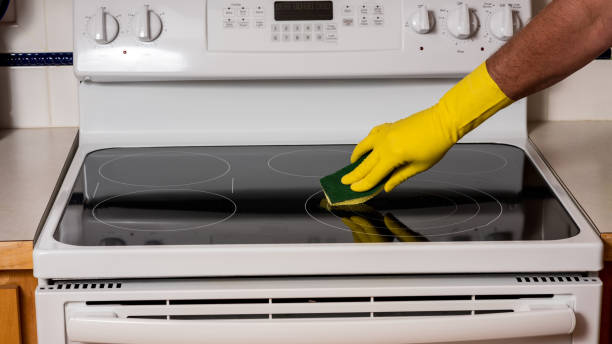 istock Main uses sponge to clean a stovetop in the kitchen 853453194
