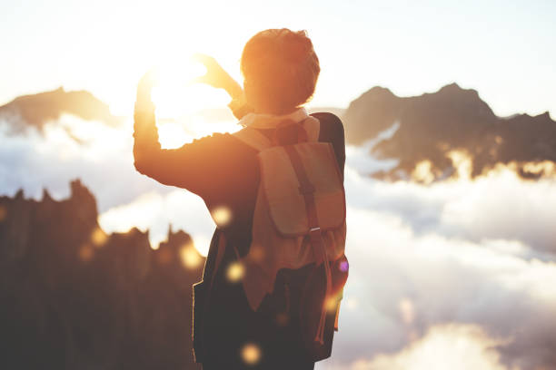 istock Woman making heart shape with hands high in mountains 853461172