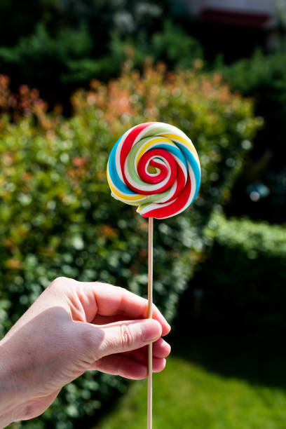 istock Holding Colorful Rainbow Lollipop 853462288