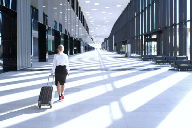 istock Business woman walking with wheeled bag 853479222
