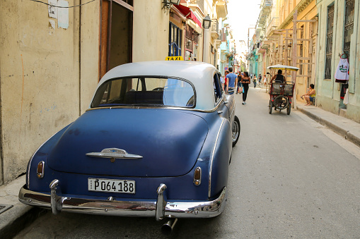 Old blue car parked on a street of old Havana, Cuba.