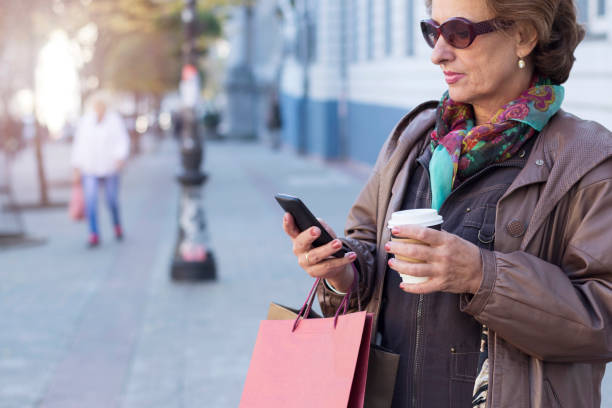istock Senior woman using a mobile on a city street 853514778