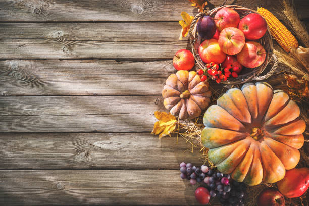 istock Thanksgiving background with pumpkins and falling leaves on rustic wooden table 853514842