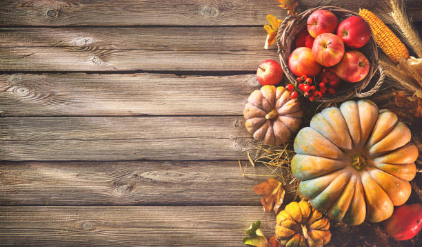 istock Thanksgiving background with pumpkins and falling leaves on rustic wooden table 853514932