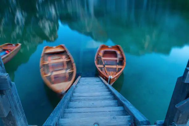 Photo of Boats on the Braies lake in the background of Seekofel mountain