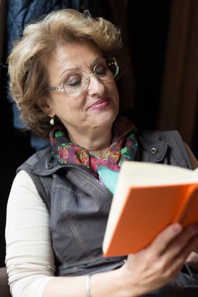 istock Senior woman reading a book in cafe 853542414