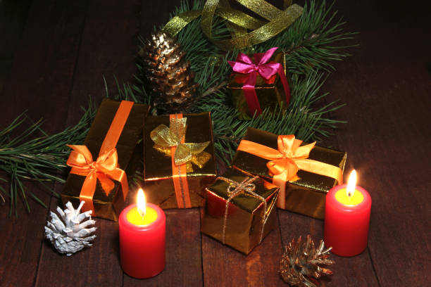 istock Christmas decorations with gift boxes, candles, tree and balls on wooden background 853547506
