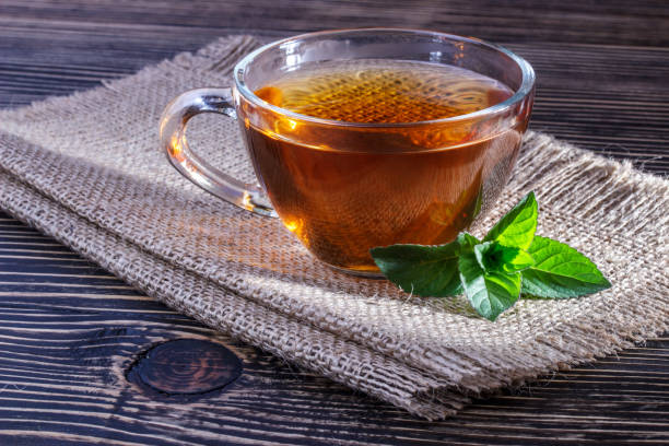 istock Cup of tea and mint on a wooden background 853551830
