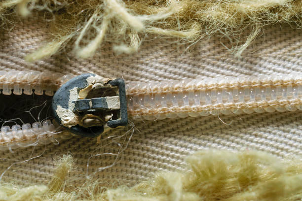 Close-Up Of Old Zipper Surrounded By Olive Green Fibers In Pattern stock photo