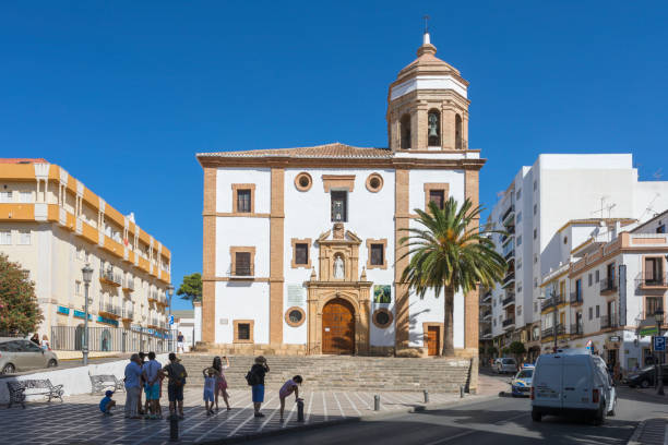 A group of tourists visits and takes pictures of a church in Ronda (Iglesia de la Merced).