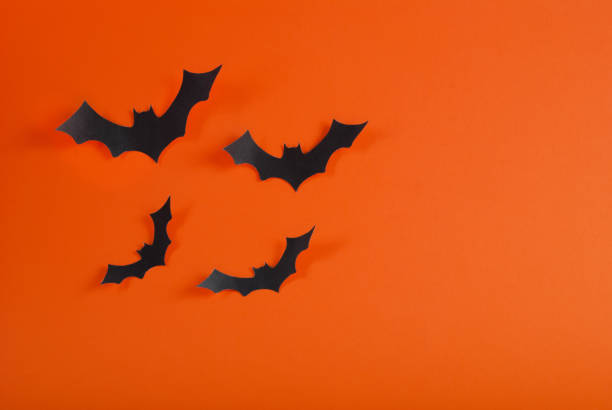 istock Bats flying on orange background with space for design 853572538