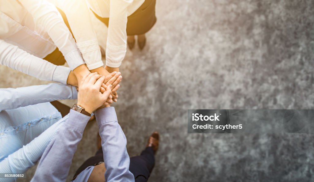 Stack of hands. Unity and teamwork concept. Close up top view of young business people putting their hands together. Stack of hands. Unity and teamwork concept. High-Five Stock Photo