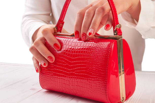 istock Red lacquered handbag in female hands. 853610992