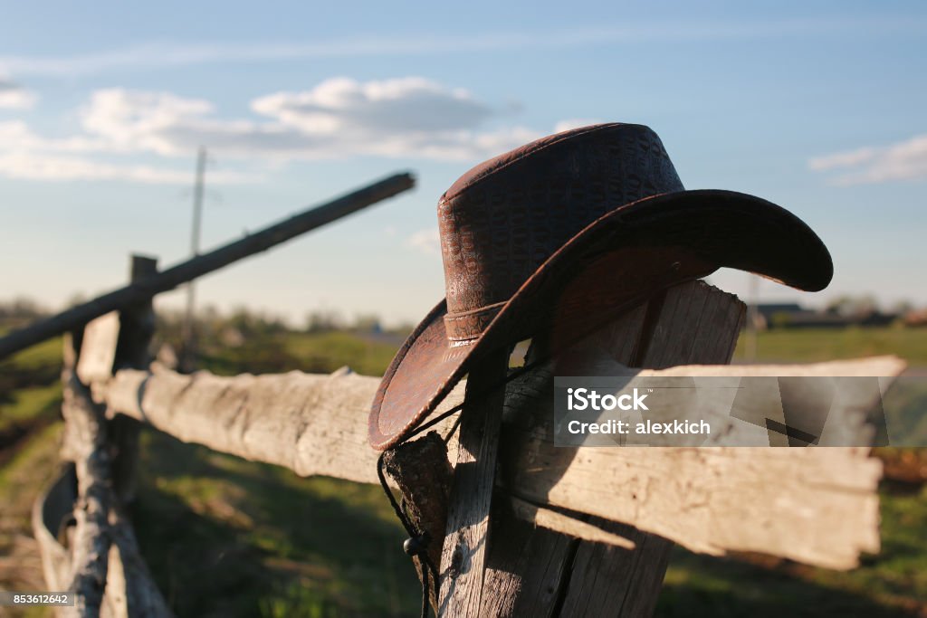 cowboy hat fence handsome and attractive person in the summer in the landscape nature and parks Ranch Stock Photo