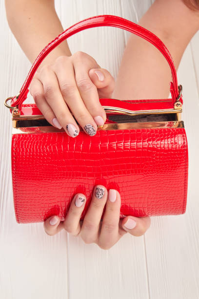 istock Red lacquered bag in female hands. 853618498