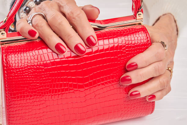 istock Luxury red handbag in female manicured hands. 853622728