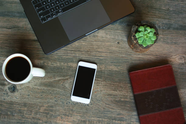 istock Succulent in Wood Pot, Coffee Cup, Leather Notebook, Laptop and Phone Over Rustic Background 853626386