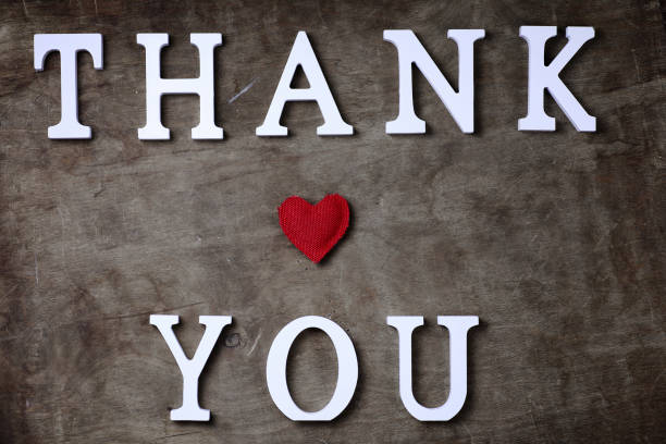 istock thank you word from white wooden letters on table and hands 853626826