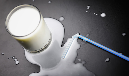 glass of milk splashing and tube straw on the table