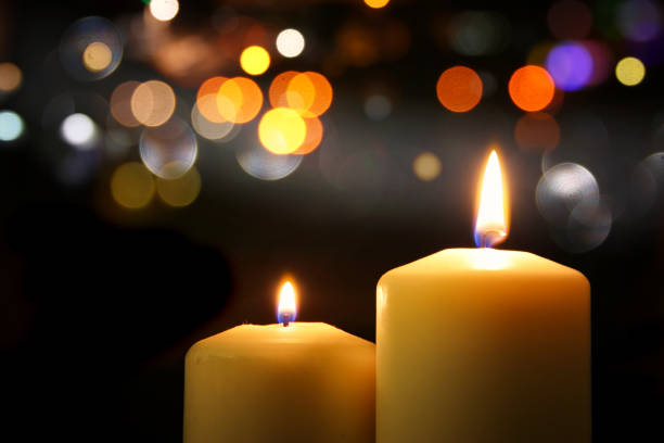 istock Burning candles over black background with bokeh glitter lights 853646434