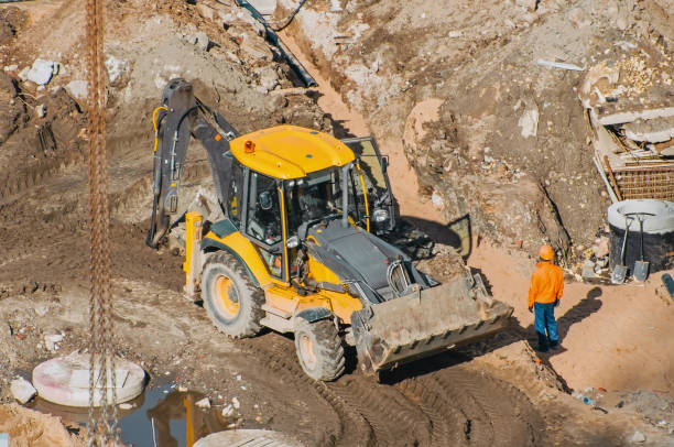 istock Tractor excavator with bucket rides running through mud lands setting, view from the height 853646784