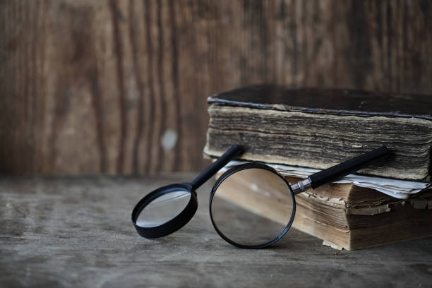 istock Old books on a wooden table and magnifier 853652910