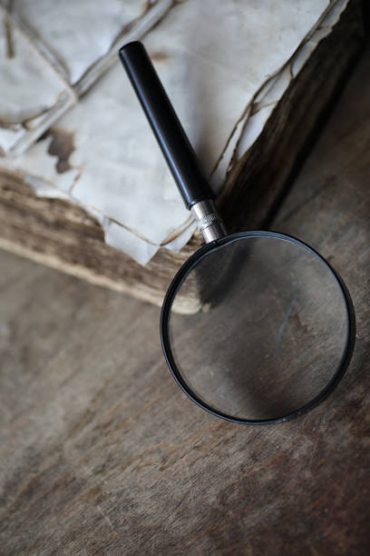 istock Old books on a wooden table and magnifier 853653352