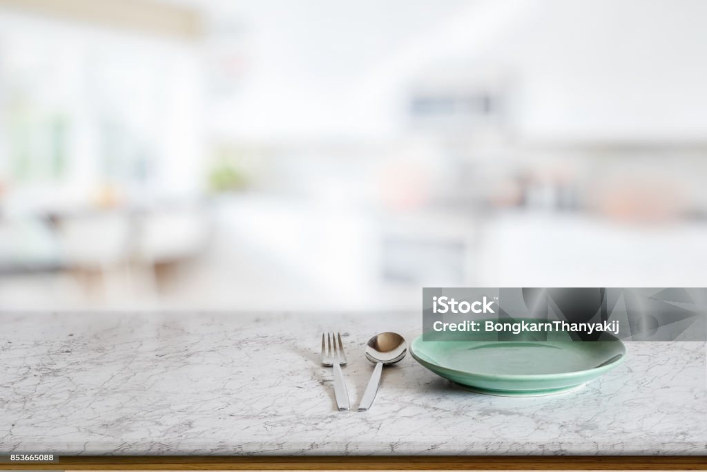 Food montage concept Empty round green ceramic dish on marble counter in blurred kitchen background. For food and product display montage. Kitchen Counter Stock Photo