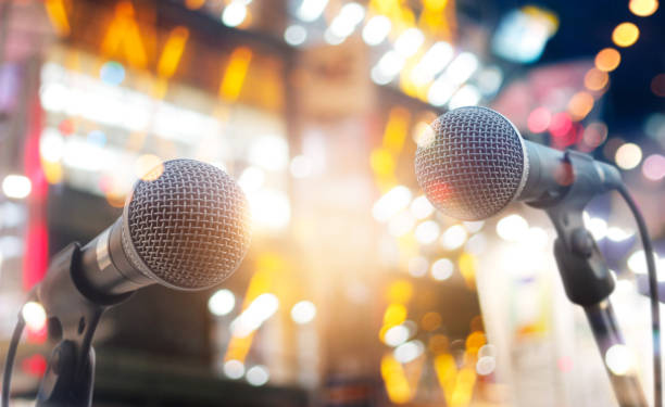istock Microphones on stage in concert on lighting background 853672486