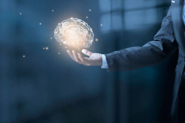 istock Businessman holding virtual human brain and stardust in hand on blue office background 853672862