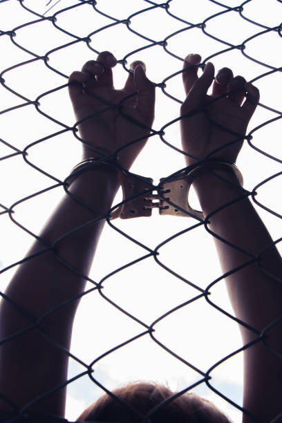 istock female holding fence background 853701076