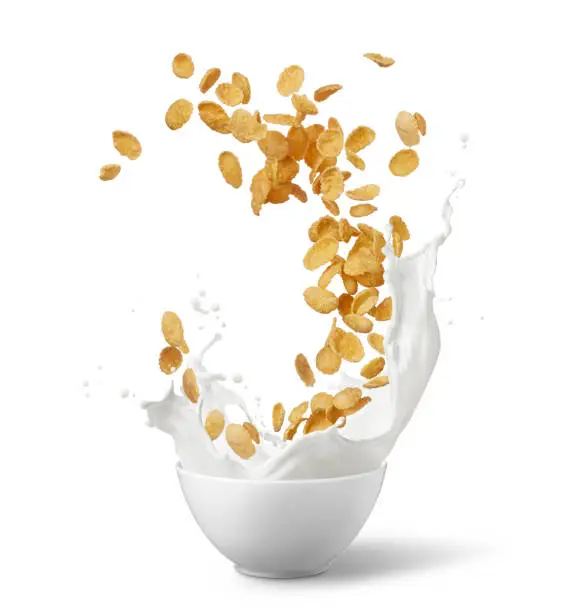 bowl of corn flakes with milk splash isolated on white