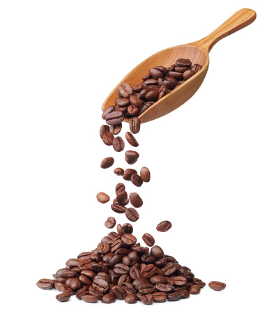 wooden spoon pouring coffee beans isolated on white