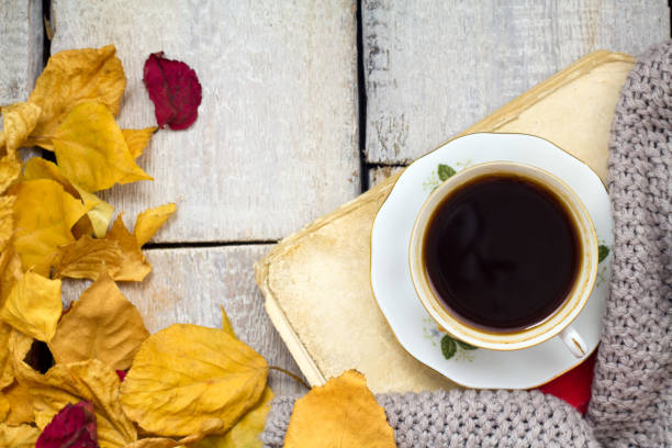 istock A cup of coffee on wooden table with fallen leaves 853714972