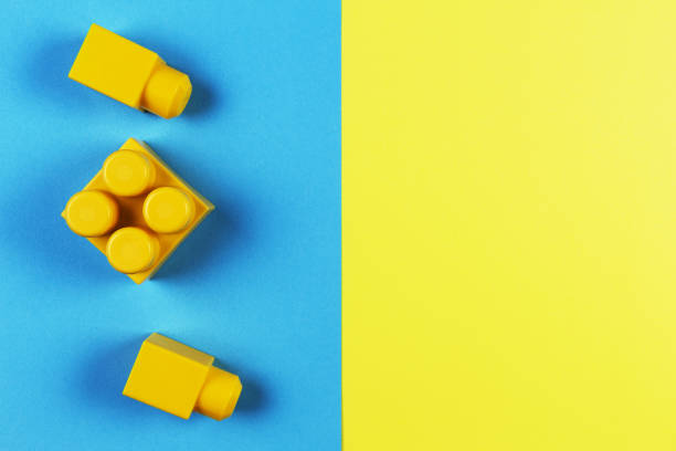 istock Yellow plastic construction blocks on yellow and blue background 853719804
