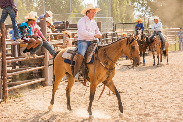 istock People Riding Horses Around a Dusty Arena 853735694