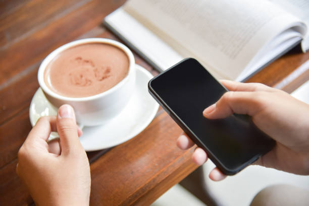 istock Woman Hands using smart phone and holding a cup of coffee. 853736778