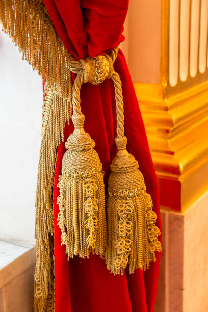 istock Golden brush on a red velvet curtain 853743446