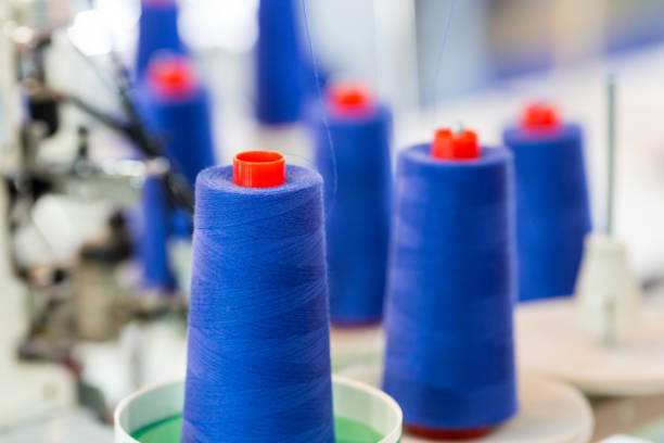 istock Spools of blue threads on sewing machine, factory 853744738