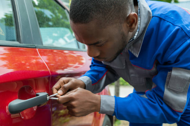 Mechanic Holding Lockpicker To Open Car Door Young Male Mechanic Holding Lockpicker To Open Red Car Door car locksmith stock pictures, royalty-free photos & images