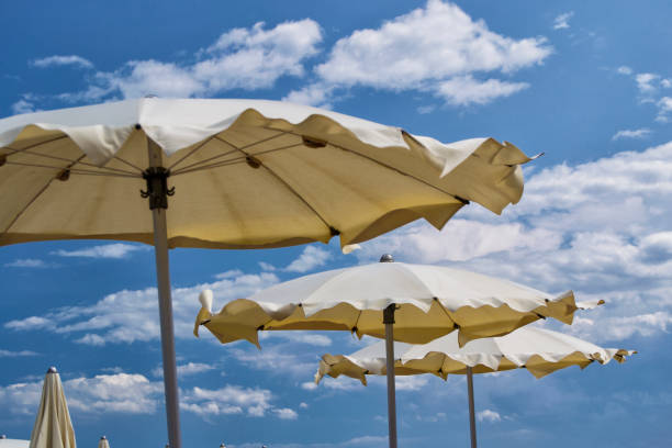 istock white parasols with blue sky and clouds. for summer seascape concept 853749312