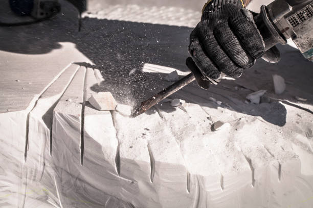 Artist sculpting marble with pneumatic hammer stock photo