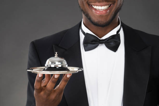 Butler in Dark Suit and White Gloves Holding Silver Serving Tray