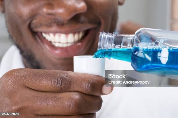 Closeup Of A Man Pouring Mouthwash Into Cap Stock Photo - Download Image Now - Mouthwash, Men, Washing